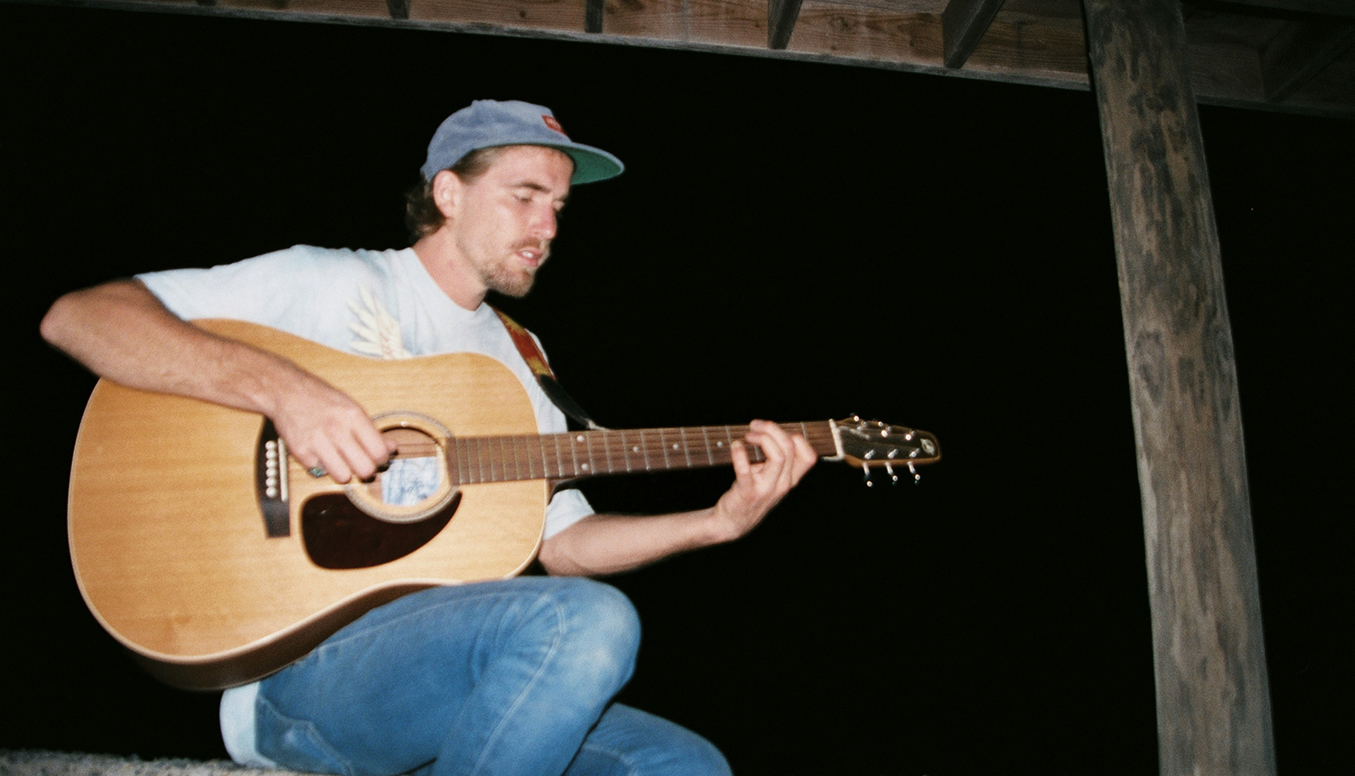man playing guitar on porch